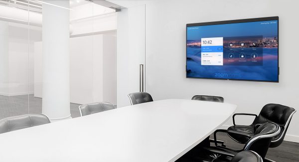 A modern conference room with a large white table and black office chairs arranged around it. On the wall is a large DTEN D7 55" screen displaying a Zoom meeting interface. The room has glass walls and a minimalist design with bright lighting.