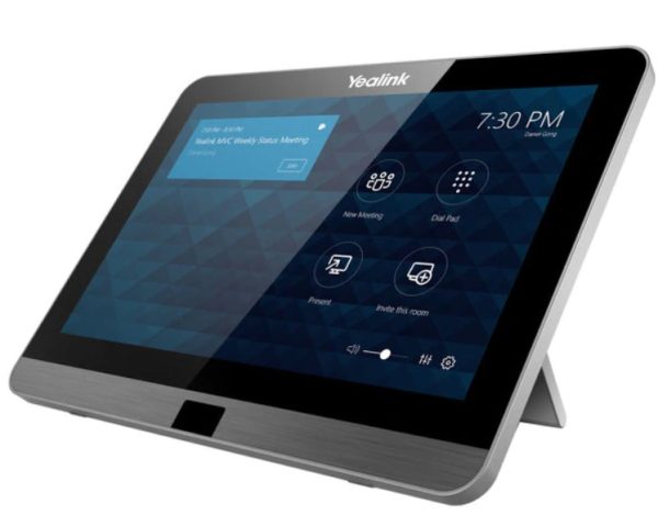 A Yealink MVC300 II touchscreen conference room tablet displaying a home screen interface with options for new meeting, dial pad, present, and invite this room. The screen also shows the time (7:30 PM) and notification of an upcoming meeting. The device features a built-in stand.